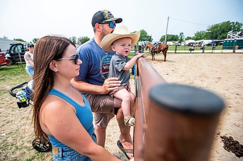 MIKAELA MACKENZIE / WINNIPEG FREE PRESS

One-year-old Riggin Krentz with his parents, Cody and Sophie Krentz, at the Manitoba Stampede in Morris on Saturday, July 22, 2023. For Tyler story.
Winnipeg Free Press 2023