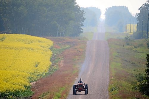 24072023
A farmer rides a tractor along a grid road south of Erickson on a smoky Monday morning. (Tim Smith/The Brandon Sun)