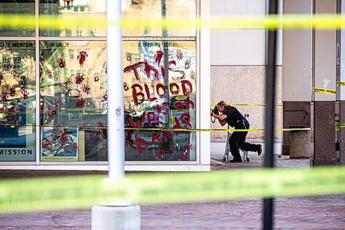 MIKAELA MACKENZIE / WINNIPEG FREE PRESS

Police investigate windows painted with protest messages at the Winnipeg Police Service headquarters on Wednesday, July 26, 2023. For &#x2014; story.
Winnipeg Free Press 2023