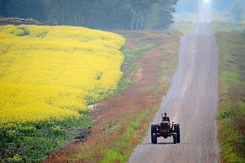 A farmer rides a tractor along a grid road south of Erickson on a smoky morning earlier this week. (Tim Smith/The Brandon Sun)