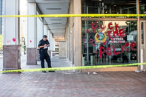 MIKAELA MACKENZIE / WINNIPEG FREE PRESS

Police investigate windows painted with protest messages at the Winnipeg Police Service headquarters on Wednesday, July 26, 2023. For &#x2014; story.
Winnipeg Free Press 2023