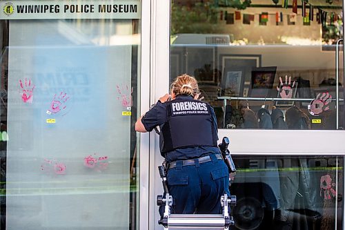 MIKAELA MACKENZIE / WINNIPEG FREE PRESS

Police investigate windows painted with protest messages at the Winnipeg Police Service headquarters on Wednesday, July 26, 2023. For &#x2014; story.
Winnipeg Free Press 2023