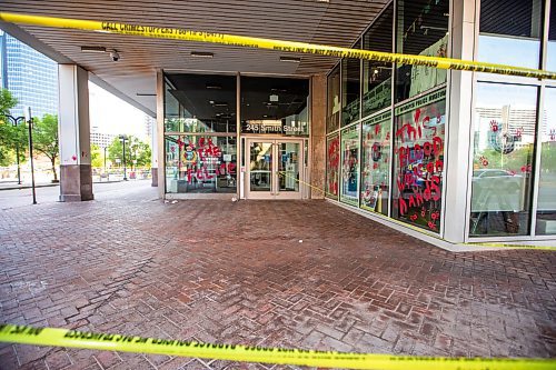 MIKAELA MACKENZIE / WINNIPEG FREE PRESS

Police investigate windows painted with protest messages at the Winnipeg Police Service headquarters on Wednesday, July 26, 2023. For &#x2014; story.
Winnipeg Free Press 2023