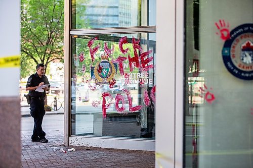 MIKAELA MACKENZIE / WINNIPEG FREE PRESS

Police investigate windows painted with protest messages at the Winnipeg Police Service headquarters on Wednesday, July 26, 2023. For &#x2014; story.
Winnipeg Free Press 2023