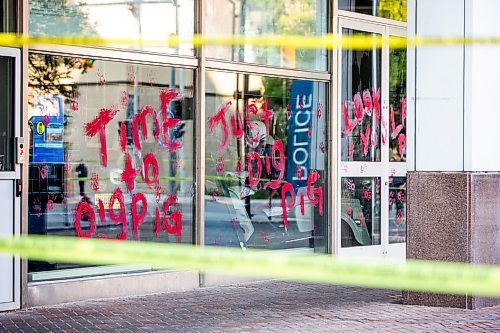 MIKAELA MACKENZIE / WINNIPEG FREE PRESS

Police investigate windows painted with protest messages at the Winnipeg Police Service headquarters on Wednesday, July 26, 2023. For &#x2014; story.
Winnipeg Free Press 2023