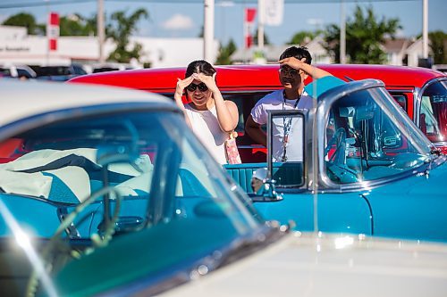 MIKAELA MACKENZIE / WINNIPEG FREE PRESS

Jannah Senangelo (left) and Lance Fuentes look at the cars at the first annual Show &amp; Shine car show at the Gauthier Cadillac Experience Centre on Thursday, July 27, 2023. Standup.
Winnipeg Free Press 2023