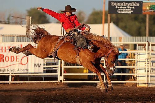Cache Schellenberg of Cochrane, Alta., is bucked but holds on during the saddle bronc event at the first go-round of the Manitoba Threshermen’s Reunion and Stampede rodeo near Austin on Thursday evening. For a story and more photos from the event, turn to A6 and A7. (Tim Smith/The Brandon Sun)