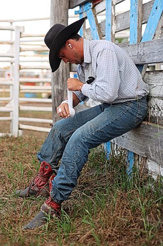 27072023
Bareback rider Ryan Livingstone of Australia tapes his hand behind the chutes before the first go-round of the Manitoba Threshermen&#x2019;s Reunion and Stampede rodeo near Austin, Manitoba on Thursday evening.  (Tim Smith/The Brandon Sun)