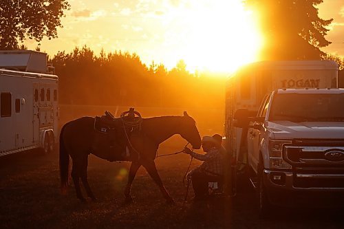 27072023
Team-roper Leonard Bales and Heather Carlson of Erickson visit with quarter-horse River as the sun sets during the first night of rodeo action at the Manitoba Threshermen&#x2019;s Reunion and Stampede near Austin, Manitoba on Thursday evening.  (Tim Smith/The Brandon Sun)