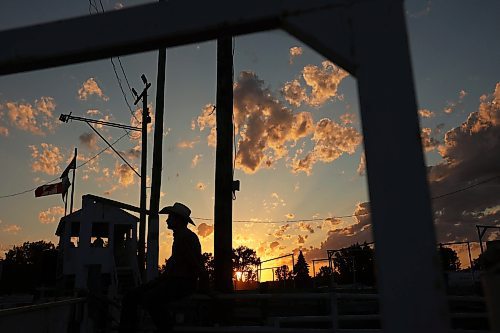 27072023
A cowboy watches the action from atop the chutes as the sun sets during the first night of rodeo at the Manitoba Threshermen&#x2019;s Reunion and Stampede near Austin, Manitoba on Thursday evening.  (Tim Smith/The Brandon Sun)