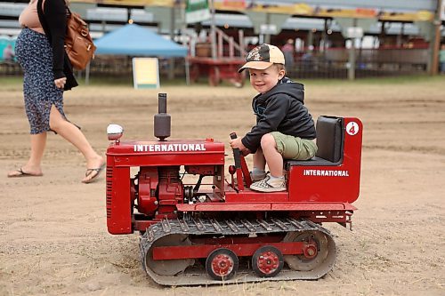 28072023
Brooks Combot of St. Eustache rides a miniature tractor while making his way to take part in the Pioneer power parade at the Manitoba Threshermen&#x2019;s Reunion and Stampede near Austin, Manitoba on Friday afternoon.  (Tim Smith/The Brandon Sun)