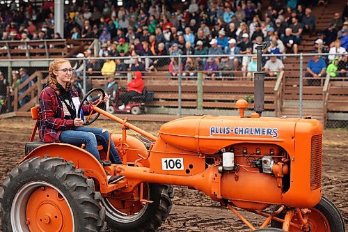 28072023
Alissa Fleury drives her dad Bill&#x2019;s 1940 Allis-Chalmers tractor while taking part in the Pioneer power parade at the Manitoba Threshermen&#x2019;s Reunion and Stampede near Austin, Manitoba on Friday afternoon.  (Tim Smith/The Brandon Sun)