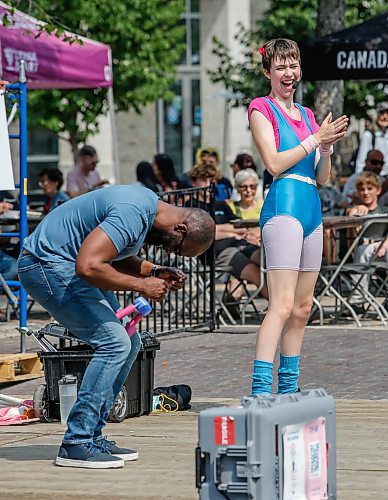 JOHN WOODS / WINNIPEG FREE PRESS
Sarah Teakle performs and looks on as audience member Lanre Ajakaiye uses a Thigh Master in her 80&#x2019;s Circus Show on the outdoor stage in Old Market Square during the Winnipeg Fringe Festival in Winnipeg, Sunday, July 30, 2023. 

Reporter: standup