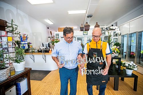 MIKAELA MACKENZIE / WINNIPEG FREE PRESS

Ernest (left) and Costa  Cholakis, co-owners of Broadway Florists, with an old truck sign at the flower shop on Academy on Monday, July 31, 2023. They are celebrating 100 years open this September. For Gabby Piche story.
Winnipeg Free Press 2023
