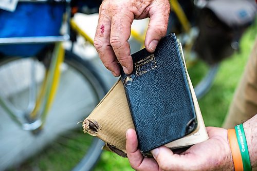 MIKAELA MACKENZIE / WINNIPEG FREE PRESS

Mic Whitty, who is on his eighth year of cycling around the world visiting every cemetery where a Commonwealth World War One or Two causality is buried, shows his grandfather&#x573; diary (which inspired the trip) at the St. Boniface Cathedral cemetery on the cross-Canada leg of his journey on Tuesday, Aug. 1, 2023. For Cierra Bettens story.
Winnipeg Free Press 2023