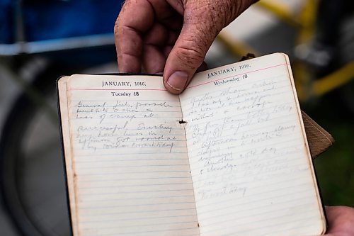 MIKAELA MACKENZIE / WINNIPEG FREE PRESS

Mic Whitty, who is on his eighth year of cycling around the world visiting every cemetery where a Commonwealth World War One or Two causality is buried, shows his grandfather&#x573; diary (which inspired the trip) at the St. Boniface Cathedral cemetery on the cross-Canada leg of his journey on Tuesday, Aug. 1, 2023. For Cierra Bettens story.
Winnipeg Free Press 2023