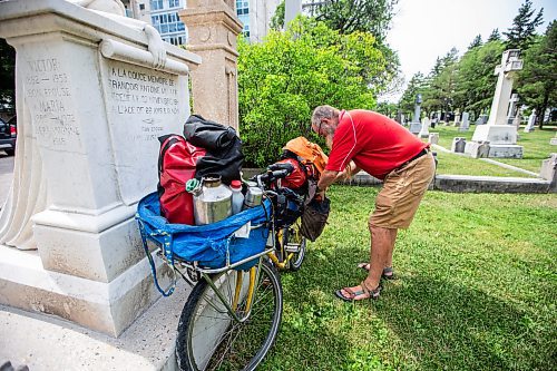 MIKAELA MACKENZIE / WINNIPEG FREE PRESS

Mic Whitty, who is on his eighth year of cycling around the world visiting every cemetery where a Commonwealth World War One or Two causality is buried, at the St. Boniface Cathedral cemetery on the cross-Canada leg of his journey on Tuesday, Aug. 1, 2023. For Cierra Bettens story.
Winnipeg Free Press 2023