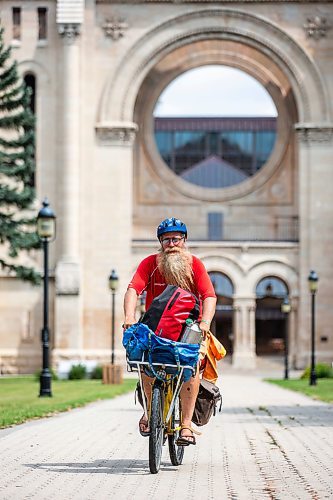 MIKAELA MACKENZIE / WINNIPEG FREE PRESS

Mic Whitty, who is on his eighth year of cycling around the world visiting every cemetery where a Commonwealth World War One or Two causality is buried, at the St. Boniface Cathedral cemetery on the cross-Canada leg of his journey on Tuesday, Aug. 1, 2023. For Cierra Bettens story.
Winnipeg Free Press 2023