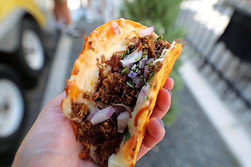 A close up of a Birria taco with braised beef in a crispy corn tortilla with mozzarella cheese, chopped red onions and Birria consomé for dipping, at the Los Brothers food truck in Brandon on Wednesday. (Michele McDougall/The Brandon Sun) 
