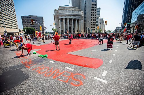 MIKAELA MACKENZIE / WINNIPEG FREE PRESS

A red dress is painted a the cenre of Portage and Main before a round dance calling for the landfills to be searched takes place on Thursday, Aug. 3, 2023. For Tessa story.
Winnipeg Free Press 2023