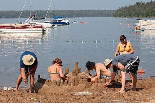 Ben Potter, Sam Pringle, Griffin Pringle, Murray Potter and Amber Hancock work together to build a large sandcastle along the shore of Clear Lake in Wasagaming on a hot Thursday. (Tim Smith/The Brandon Sun)