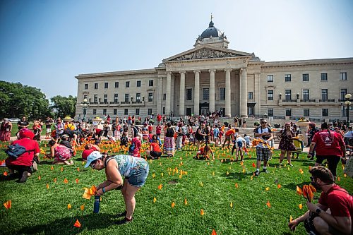 MIKAELA MACKENZIE / WINNIPEG FREE PRESS

Folks plant orange flags at the legislature after a rally calling for the landfills to be searched on Thursday, Aug. 3, 2023. For Tessa story.
Winnipeg Free Press 2023