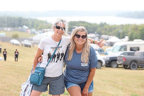 Corinne Mitchell and Denis Wolfe pose for a photo on a hill overlooking the Rockin' the Fields of Minnedosa festival grounds on Friday afternoon. (Kyle Darbyson/The Brandon Sun)