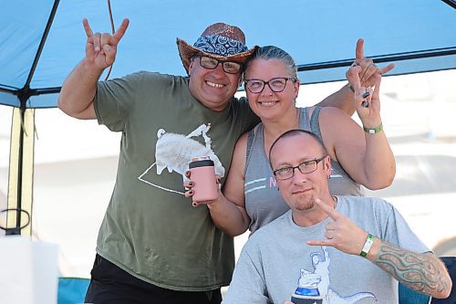 Jeff and Kristina Dalik rock out in the shade alongside their friend Trevor Kemp during the first day of this year’s Rockin’ the Fields of Minnedosa festival. (Kyle Darbyson/The Brandon Sun)