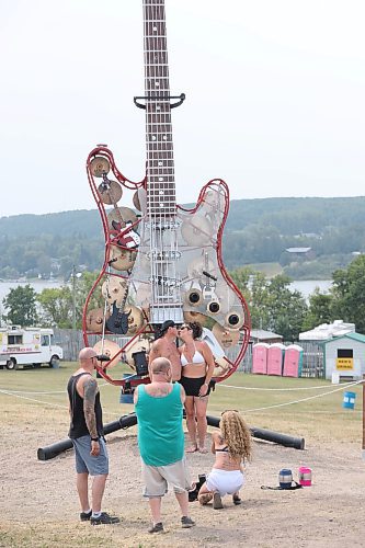 Nolan and Patty Kuruliak share a quick kiss next to a 25-foot guitar that is situated between the two main stages of this year’s Rockin’ the Fields of Minnedosa festival. Nolan told the Sun afterwards that he proposed to his wife 18 years ago at this very festival. (Kyle Darbyson/The Brandon Sun)