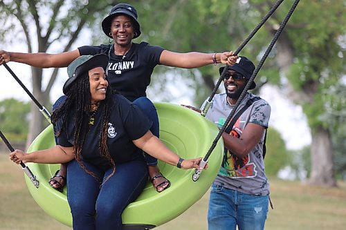 Shevado Lyston pushes his partner Imani Griffiths and her mother Audrey Denton on a swing set at Rideau Park during the Jamaica Independence Day celebration that took place over the long weekend. (Kyle Darbyson/The Brandon Sun)