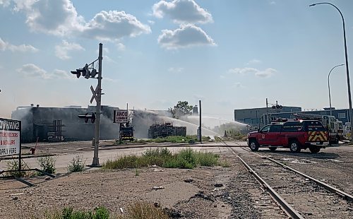 By the late aftertoon, three fire trucks were stationed at the scene as crews continued hosing down the building on the 900 block of Logan Avenue. August. 6, 2023. (Cierra Bettens / Winnipeg Free Press)
