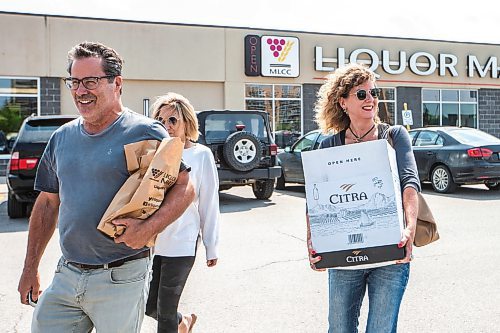 MIKAELA MACKENZIE / WINNIPEG FREE PRESS

Scott Irving (left), Kelly Thompson, and Kim Irving walk out of the Grant Park Liquor Mart (with alcohol purchased for a trip to the cabin) on Tuesday, Aug. 8, 2023. For Malak Abas story.
Winnipeg Free Press 2023