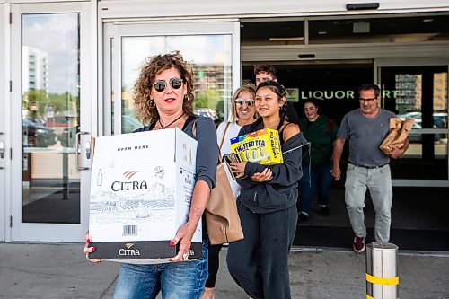 MIKAELA MACKENZIE / WINNIPEG FREE PRESS

Kim Irving (left), Kelly Thompson, Cena Murphy, and Scott Irving walk out of the Grant Park Liquor Mart (with alcohol purchased for a trip to the cabin) on Tuesday, Aug. 8, 2023. For Malak Abas story.
Winnipeg Free Press 2023