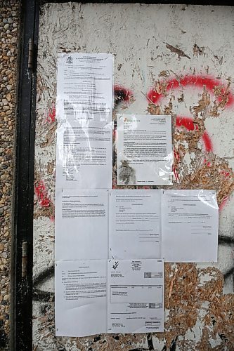 Several notices from the City of Brandon are posted to the outside of the former Esso gas station on Rosser Avenue in downtown Brandon. The owner has been ordered by the City of Brandon to demolish the structure, and has until Aug. 16 to appeal that order. (Matt Goerzen/The Brandon Sun)