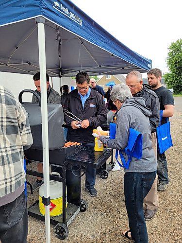 Dan Mazier, Member of Parliament for Dauphin-Swan River-Neepawa, handed out freshly barbecued hotdogs to constituents who braved the rain on Aug. 10 to come out to his community barbecue and popup passport event at the Minnedosa Legion #138. (Miranda Leybourne/The Brandon Sun)