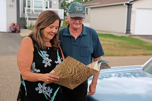 Jim and Lianne Christie look through the original brochure for their 1962 Ford Thunderbird two-door hardtop, in Brandon on Wednesday. (Michele McDougall/The Brandon Sun)