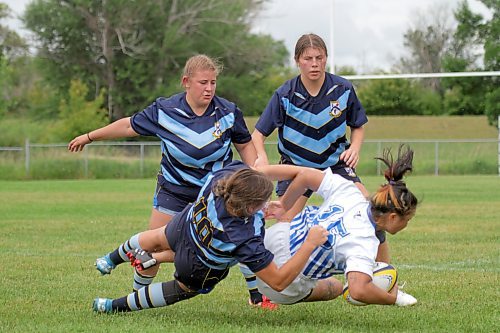 Brianne Zemliak, who dislocated her kneecap a few weeks ago, tackles a WInnipeg Assassins ball carrier while Haley Wakelam, left, and Brooklyn Zemliak look on during their Rugby Manitoba premier women's league match at John Reilly Field on Saturday. (Thomas Friesen/The Brandon Sun)