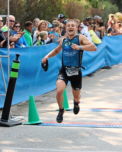 Josh Malenchak erupts in joy as he wins the Olympic race at the 31st edition of the Riding Mountain Triathlon at Wasagaming in 2017 as he crosses the old finish line at the corner of Columbine Street and Wasagaming Drive. The race now finishes along the lake to allow the intersection to open more quickly. (Perry Bergson/The Brandon Sun)