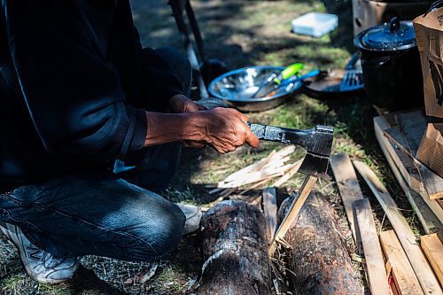 MIKAELA MACKENZIE / WINNIPEG FREE PRESS

Camp elder Marcel Branch chops kindling to boil water on the grill for coffee at Camp Marcedes (beside the Canadian Museum for Human Rights) on Monday, Aug. 14, 2023. For Cierra Bettens story.
Winnipeg Free Press 2023