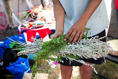 MIKAELA MACKENZIE / WINNIPEG FREE PRESS

Firekeeper Shining Goldstar shows medicinal cedar, sage, and juniper at Camp Marcedes (beside the Canadian Museum for Human Rights) on Monday, Aug. 14, 2023. For Cierra Bettens story.
Winnipeg Free Press 2023