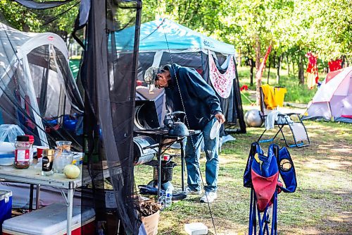 MIKAELA MACKENZIE / WINNIPEG FREE PRESS

Camp elder Marcel Branch boils water on the grill for coffee at Camp Marcedes (beside the Canadian Museum for Human Rights) on Monday, Aug. 14, 2023. For Cierra Bettens story.
Winnipeg Free Press 2023