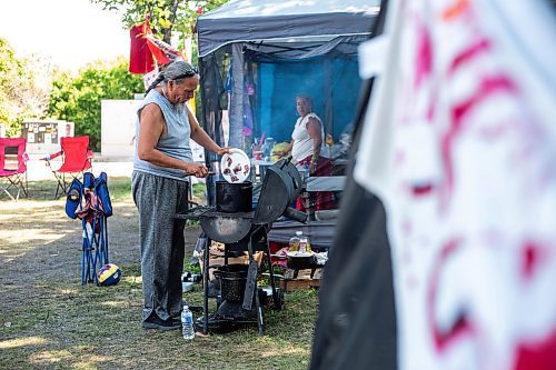 MIKAELA MACKENZIE / WINNIPEG FREE PRESS

James Aster makes a stew on the grill at Camp Marcedes (beside the Canadian Museum for Human Rights) on Monday, Aug. 14, 2023. For Cierra Bettens story.
Winnipeg Free Press 2023