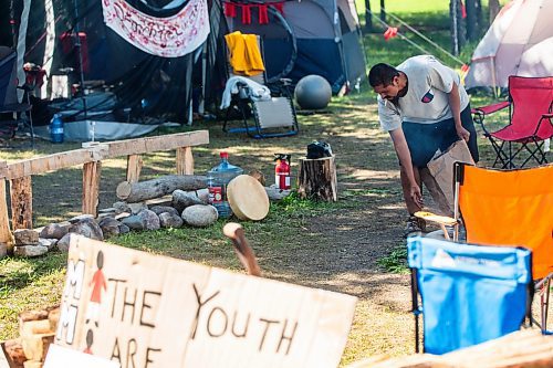 MIKAELA MACKENZIE / WINNIPEG FREE PRESS

Firekeeper Shining Goldstar adds cedar to protect and strengthen the circle around the sacred fire at Camp Marcedes (beside the Canadian Museum for Human Rights) on Monday, Aug. 14, 2023. For Cierra Bettens story.
Winnipeg Free Press 2023