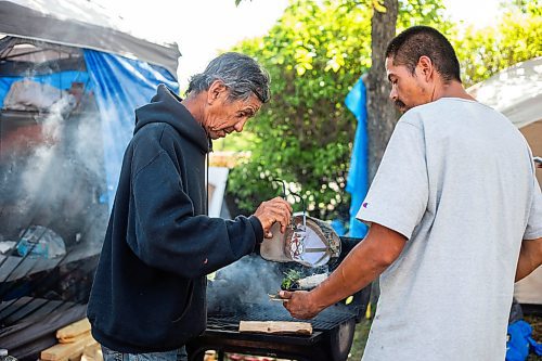 MIKAELA MACKENZIE / WINNIPEG FREE PRESS

Firekeeper Shining Goldstar (right) smudges camp elder Marcel Branch at Camp Marcedes (beside the Canadian Museum for Human Rights) on Monday, Aug. 14, 2023. For Cierra Bettens story.
Winnipeg Free Press 2023