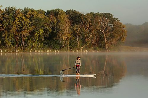 14082023
Tracy Ramage paddleboards along the smooth-as-glass surface of Lake Clementi south of Brandon as fog rolls over the lake shortly after sunrise on Monday morning.
(Tim Smith/The Brandon Sun)