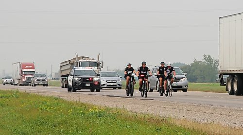 A Brandon Police Service cruiser being driven by Const. Denis Dufault, follows three BPS members accompanying CFB Shilo soldier Rob Nederlof on the Trans-Canada Highway during his 1,000-kilometre trek to raise funds and awareness for the Wounded Warrior PTSD service dog program. From left, Const. Selena Samagalski, Const. Amanda Conway, Const. Meghan Puteran, and Nederlof. (Photos by Michele McDougall/The Brandon Sun)

