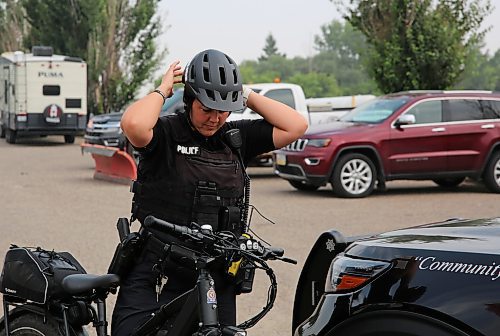 Cst. Meghan Puteran with Brandon Police Service, adjusts her helmet as she prepares to cycle from Brandon to Shilo, accompanying soldier Rob Nederlof on his 1,000 kms trek to raise funds and awareness for the Wounded Warrior PTSD Service Dogs program, in Brandon on Tuesday. (Michele McDougall/The Brandon Sun)