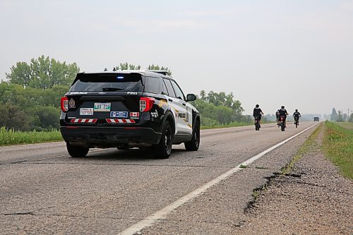 Cst. Dufault in a Brandon Police Service (BPS) police cruiser on Highway 468, east of Brandon, following three BPS constables and Shilo soldier Rob Nederlof on his 1,000 km trek to raise funds and awareness for the Wounded Warrior PTSD Service Dogs program in Brandon on Tuesday. (Michele McDougall/The Brandon Sun)