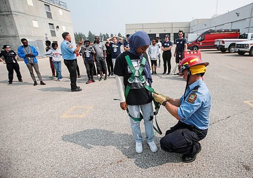 JOHN WOODS / WINNIPEG FREE PRESS
Mariam Wancha, who came from Ethiopia in 2019, gets a harness on so she can go up a ladder truck at the Winnipeg Fire Paramedic Service (WFPS) training academy in Winnipeg, Tuesday, August 15, 2023. The WFPS hosted 36 newcomer youth at a two-day skills training career camp.

Reporter: cierra
