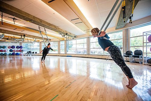 MIKAELA MACKENZIE / WINNIPEG FREE PRESS

Lori Orchard leads Jen Zoratti in an anti-gravity workout, which uses suspended hammocks for an arial-style workout, at the Wellness Institute on Tuesday, Aug. 15, 2023. For Jen story.
Winnipeg Free Press 2023